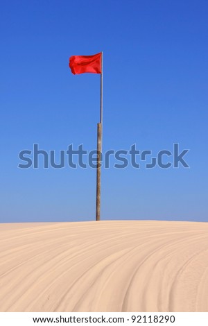 Red flag marker on the racing track in sand