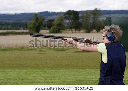 Young boy holding the gun before clay pigeon shooting
