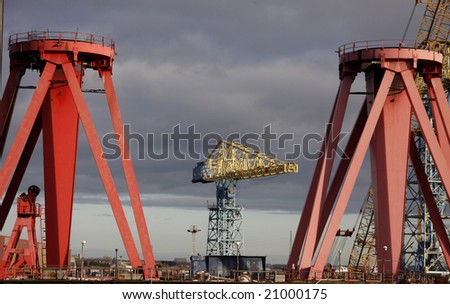 Parts of tow disused cranes at either side of the crane in use