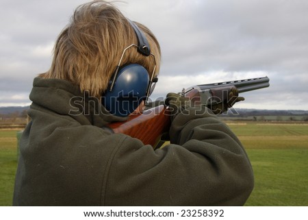 Teenage boy shooting at the clay pigeon
