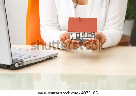 real estate concept with a mini house and laptop at the office