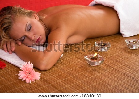 young and beautiful woman at the spa center having body care