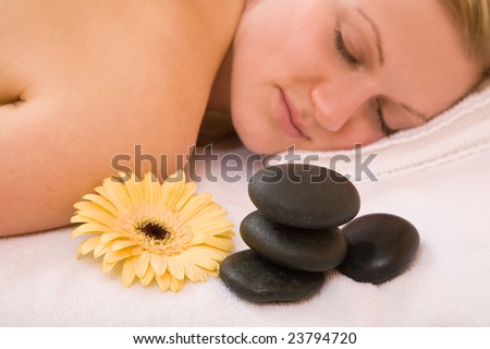 Massage session for a woman at the spa center with volcanic stones
