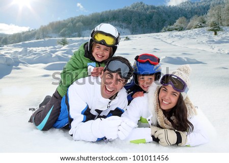 Happy family laying down in the snow
