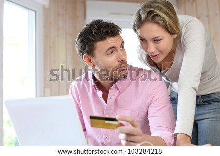 Couple using credit card to shop online