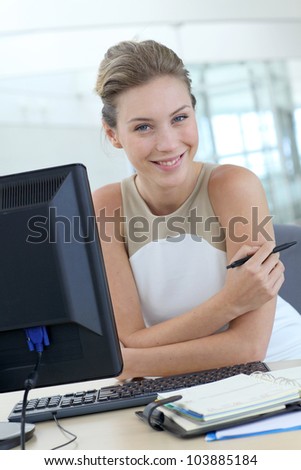 Beautiful blond office-worker sitting at her desk