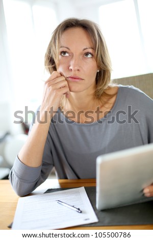 Woman at home having trouble to fill in tax form