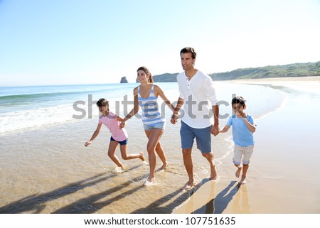 Family having fun running on the beach
