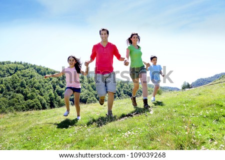 Happy family enjoying and running together in the mountains