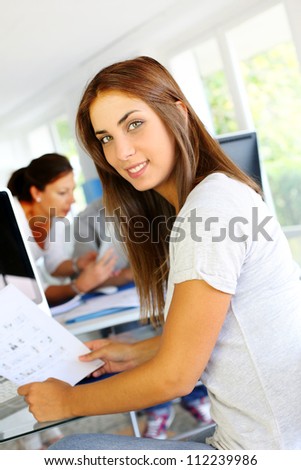 Beautiful office worker sitting in front of desktop