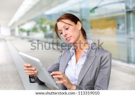 Executive woman standing outside with digital tablet