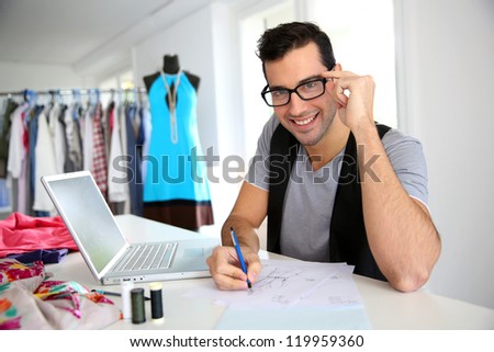 Smiling fashion designer in workshop