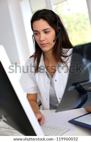 Portrait of smiling medical secretary working on desktop