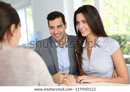 Young couple signing financial contract