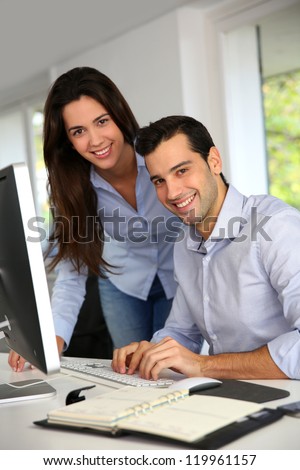Young office workers in front of desktop computer