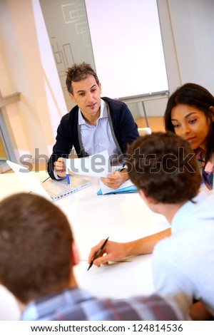 Teacher giving business presentation to students