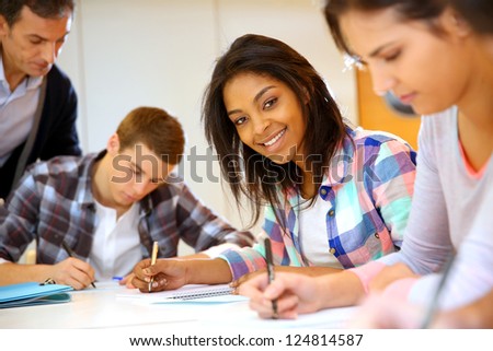 Group of teenagers in class writing an exam