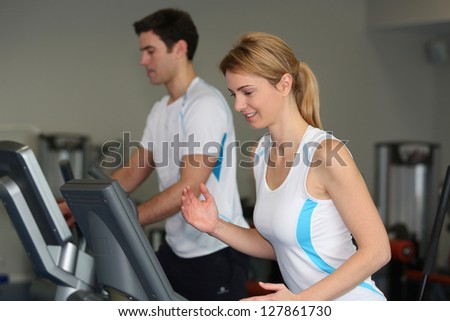 Couple in fitness gym using running belt