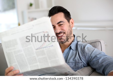 Man relaxing at home with newspaper