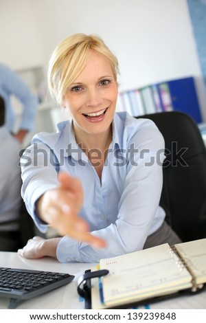 Businesswoman giving handshake to client