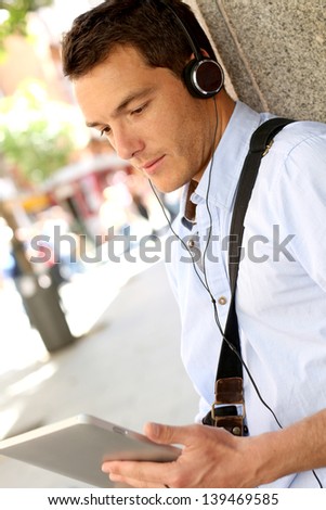 Casual man in town using digital tablet