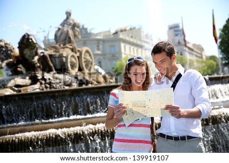 Couple of tourists reading map in Plaza de Cibeles, Madrid
