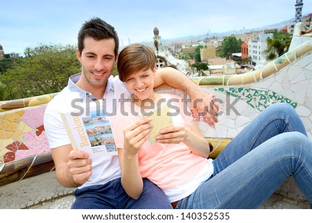 Tourists reading travel book in Guell Park, Barcelona