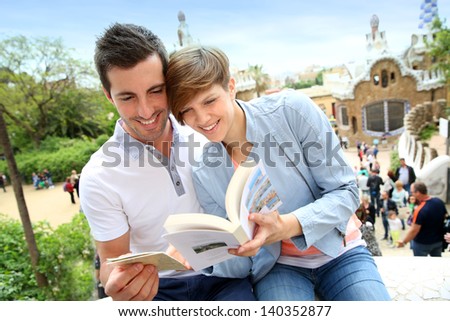 Couple in Barcelona reading travel guide