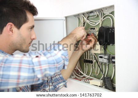 Electrician fixing cable in domestic electrical box