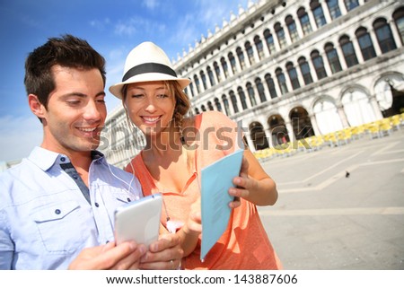 Couple in Venice looking at tourist information on smartphone