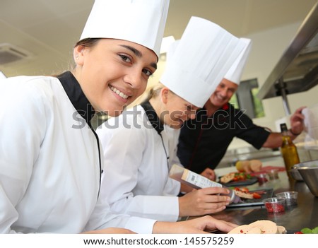 Team of young chefs preparing delicatessen dishes