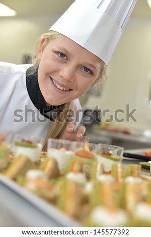 Young caterer preparing tray of appetizers