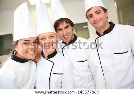 Team of future restaurant chefs looking at camera