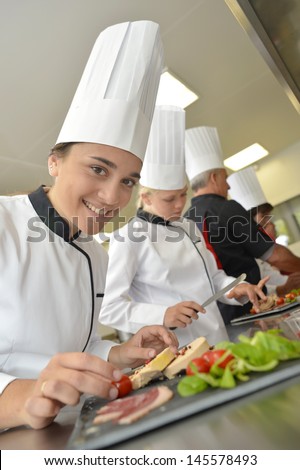 Team of young chefs preparing delicatessen dishes