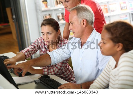 Teenagers with teacher in computers' class