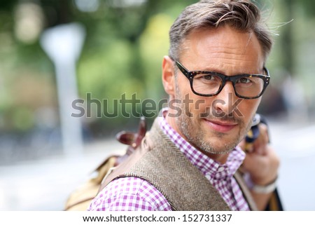 Trendy smiling guy traveling with bag
