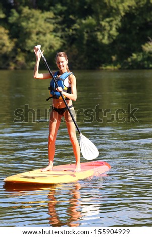 Woman riding stand-up-paddle on river