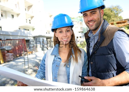 Smiling architects standing on construction site