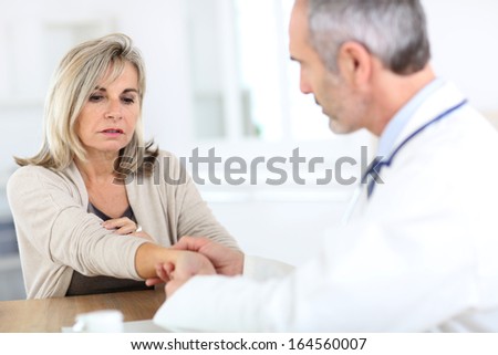 Senior woman with wrist pain consulting doctor