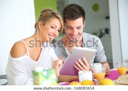 Couple reading news on digital tablet