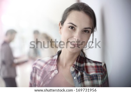 Smiling student girl standing in hall