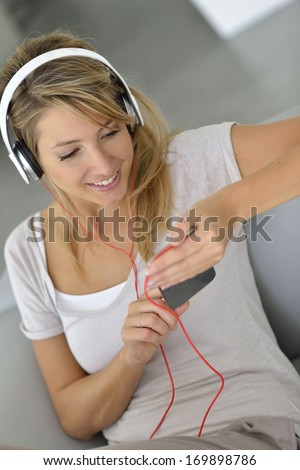 Blond woman listening to music with smartphone