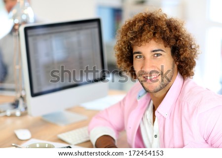 Young man in office working on desktop computer