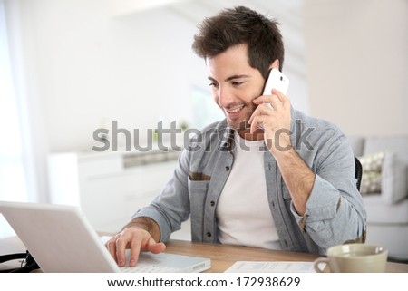 Salesman working from home and talking on phone