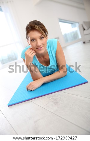 Beautiful fitness woman laying in gym floor
