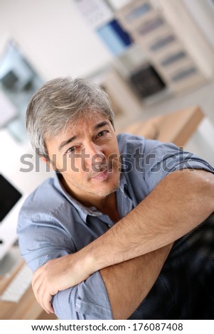 Smiiling mature man relaxing in office chair