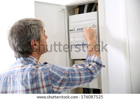 Technician checking on electric box in private home