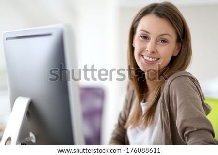 Smiling woman in office sitting at desktop