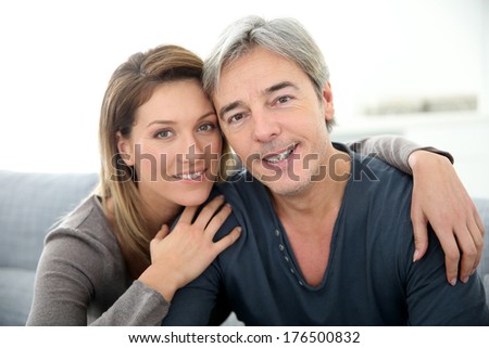 Middle-aged couple relaxing on sofa at home