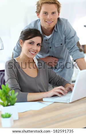 Young people in office working on laptop